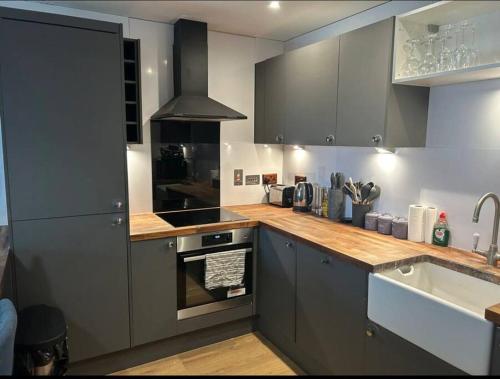 a kitchen with a sink and a stove top oven at 2 bed apartment close to station with parking in London