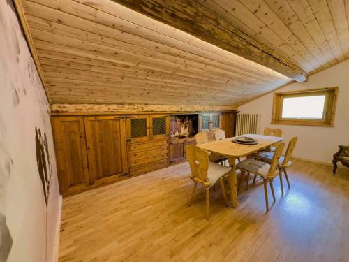 uma sala de jantar com uma mesa de madeira e cadeiras em Bormio House con vista pista Stelvio em Bormio