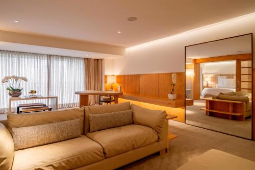 a living room with a couch and a bedroom at Hotel Emiliano in Sao Paulo