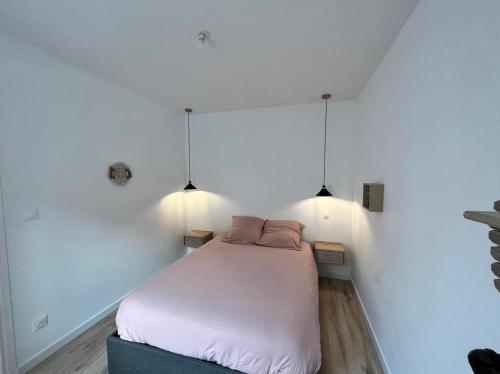 a bedroom with a bed in a white wall at L'escale Amiénoise Loft in Amiens