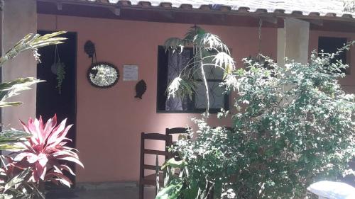 Casa temporada maricá في ماريكا: منزل أمامه مجموعة من النباتات