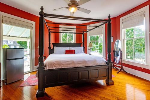 um quarto com uma cama com uma parede laranja em Anticipation Room in Camellia Rose Inn Downtown em Gainesville