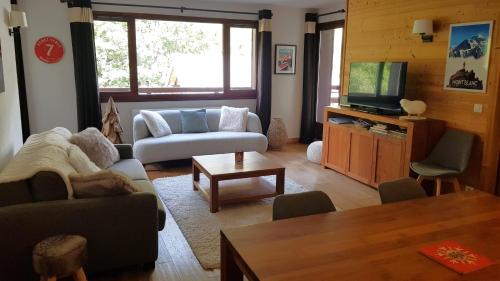 uma sala de estar com um sofá e uma televisão em Le calme, le confort, la nature, skis aux pieds, à 15 kilomètres de Chamonix em Vallorcine