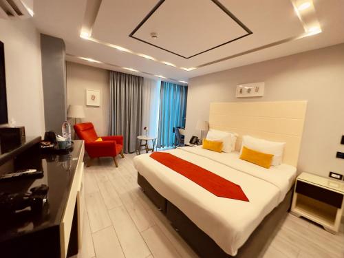 a hotel room with a large bed and a red chair at Petra Boutique Hotel in Wadi Musa