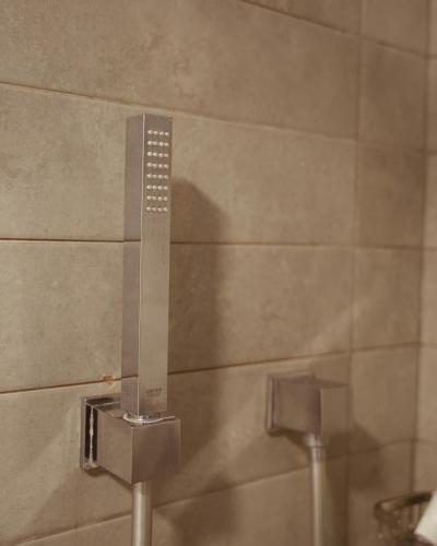 a metal urinal in a bathroom with a wall at Petra Boutique Hotel in Wadi Musa
