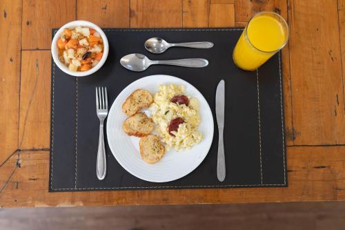 a table with a plate of food and a glass of orange juice at H2 Platinum Lourdes in Belo Horizonte