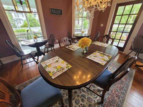 een eetkamer met een houten tafel en stoelen bij Lady Clare Room at Camellia Rose Inn Downtown in Gainesville