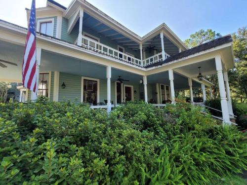 een huis met een Amerikaanse vlag op de veranda bij Lady Clare Room at Camellia Rose Inn Downtown in Gainesville