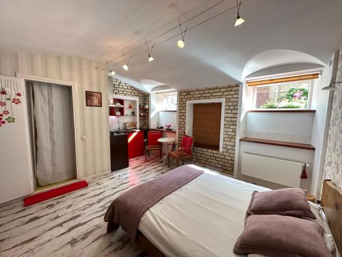 a bedroom with a large bed and a kitchen at Old Town cosy one bedroom apartments with fireplace in Vilnius