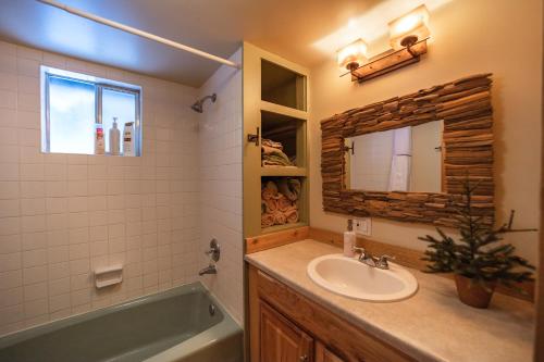 a bathroom with a sink and a tub and a mirror at Leavenworth Mountain View Cabin w/ Space to Hike in Leavenworth