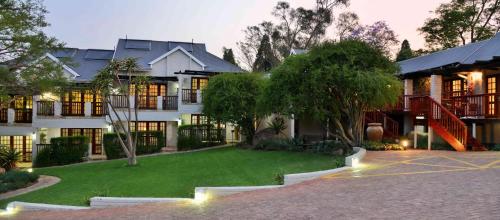 a large house with a lawn in front of it at Rivonia Premier Lodge in Johannesburg
