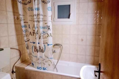 bagno con vasca e tenda doccia di Relax Home a Ayía Marína