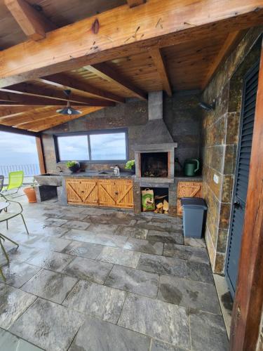 a stone patio with a fireplace in a house at Blue Horizon, Sea and Mountain view in Estreito da Calheta