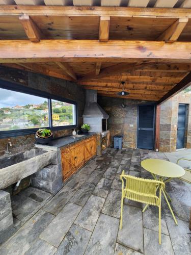 a patio with a table and a table and a chair at Blue Horizon, Sea and Mountain view in Estreito da Calheta