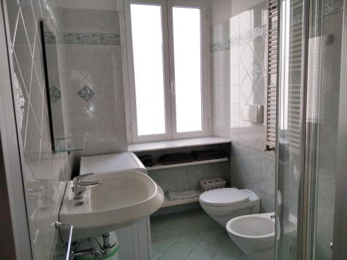 a bathroom with a sink and a toilet and a window at Casa Artisti in Carrara