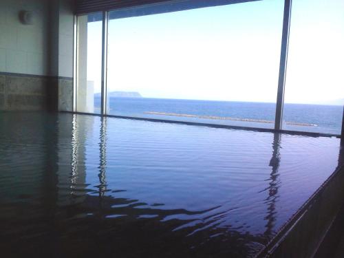 a room with water on the floor and a large window at Ibusuki Kaijo Hotel in Ibusuki