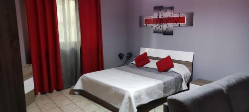 sypialnia z łóżkiem z 2 czerwonymi poduszkami w obiekcie Home away from Home w mieście Żurrieq
