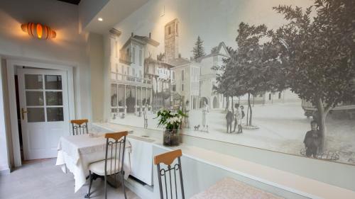 a dining room with a wall mural of a street at Albergo Pesce D'oro in Verbania