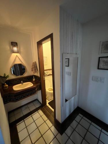 a bathroom with a sink and a mirror at Casa em geribá in Búzios