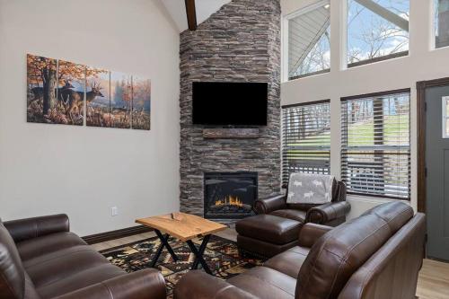 a living room with couches and a fireplace at Rock and Timber Lodge in Branson