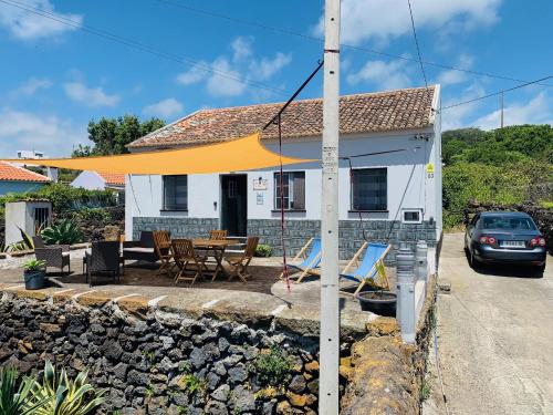 a house with a yellow umbrella over a patio at Casa Avô São Miguel in Angra do Heroísmo
