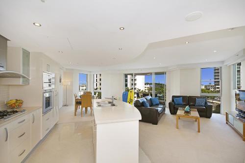 a kitchen and living room with a couch and a table at Aqua Vista Resort in Maroochydore