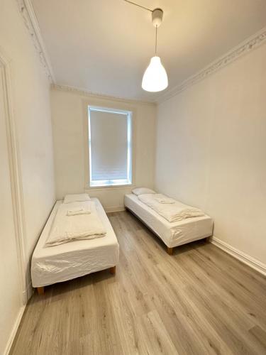 two beds in a room with a window at Grunerløkka Apartments in Oslo