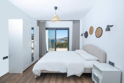 a white bedroom with a large bed and a window at Villa Al Mare Özel Havuzlu Villa in Bodrum City