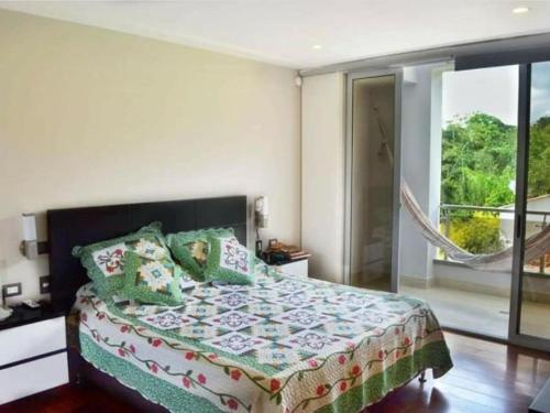 ein Schlafzimmer mit einem Bett und einem Balkon in der Unterkunft villa En la mesa de los Santos in Los Santos