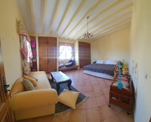 una sala de estar con cama y sofá y una habitación con cama en Lara House 1, en Agadir