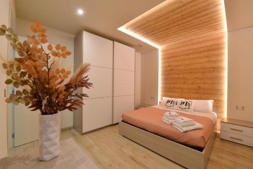 um quarto com uma cama e um vaso com toalhas em Casa Sogno em Aosta