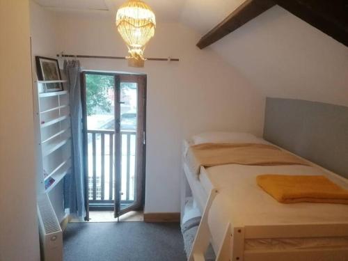 um quarto com uma cama e uma porta para uma varanda em The Old Barn, Cosy Townhouse in Leominster em Leominster