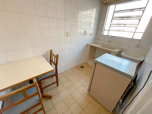 a small kitchen with a table and a sink at Central Park Hotel Residence in São Carlos