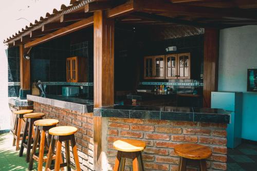 una fila di sgabelli di legno di fronte a un bar di HOTEL MANTA BEACH MADRIGAL a Manta