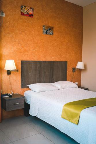 a bedroom with a large bed and two lamps at HOTEL MANTA BEACH MADRIGAL in Manta