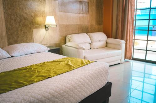 una camera d'albergo con letto e sedia di HOTEL MANTA BEACH MADRIGAL a Manta
