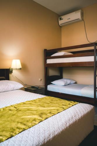 a room with two bunk beds and a lamp at HOTEL MANTA BEACH MADRIGAL in Manta