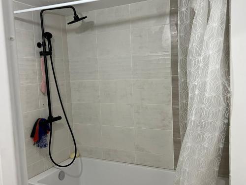 y baño con ducha y cortina de ducha. en Champions home, en Sarcelles