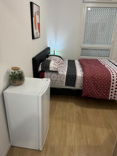 1 dormitorio con 1 cama y nevera blanca en Champions home, en Sarcelles