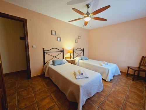 a bedroom with two beds and a ceiling fan at Lagar de Palacio in Santa Cilia de Jaca