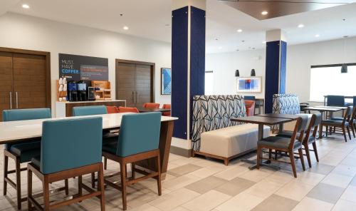 a dining room with tables and chairs and a counter at Holiday Inn Express Hotel & Suites Cedar Hill, an IHG Hotel in Cedar Hill