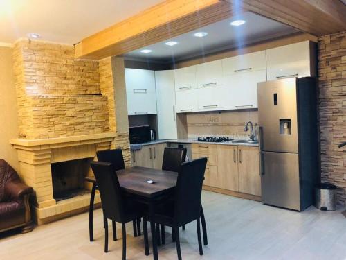巴庫里阿尼的住宿－SNOW HOUSE BAKURIANI!，厨房配有桌椅和冰箱。