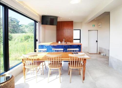 a kitchen with a wooden table and chairs at セナはハウスB02 in Yomitan