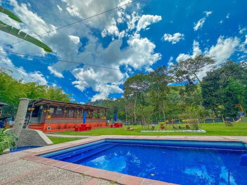 a swimming pool in a yard with a playground at CABAÑAS Finca Hotel Villa Natalia -Salento Quindio in Salento