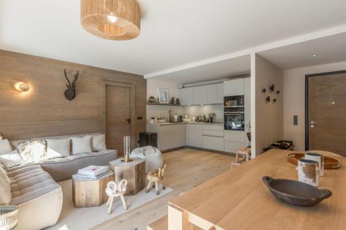 un salon avec un canapé et une table dans l'établissement Appartement du Cerf - Welkeys, à Megève