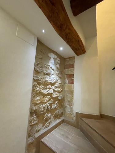 eine Steinmauer in der Ecke eines Zimmers mit Treppe in der Unterkunft CASA KiKA in Penáguila