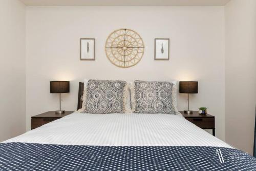 a bedroom with a blue and white bed with two lamps at Light N Airy, Pool, Hot Tub, Pets, Ground Floor in Invermere