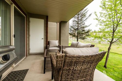 a screened porch with wicker chairs and a door at Light N Airy, Pool, Hot Tub, Pets, Ground Floor in Invermere