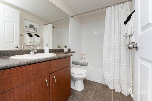 a bathroom with a sink and a toilet and a shower at Light N Airy, Pool, Hot Tub, Pets, Ground Floor in Invermere