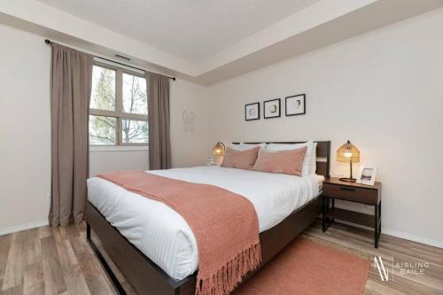 a bedroom with a large bed and a window at Light N Airy, Pool, Hot Tub, Pets, Ground Floor in Invermere